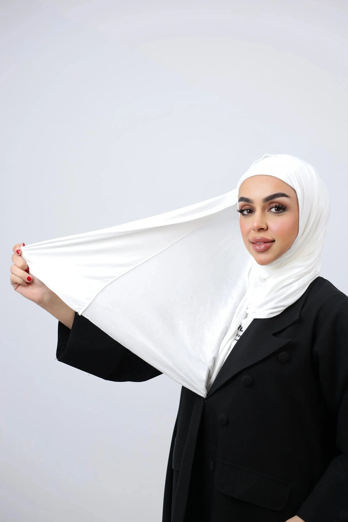A woman wearing a white cotton double stretch hijab with a plain style.