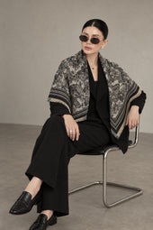 BLACK cashmere animal print square shawl folded into a triangle — seated